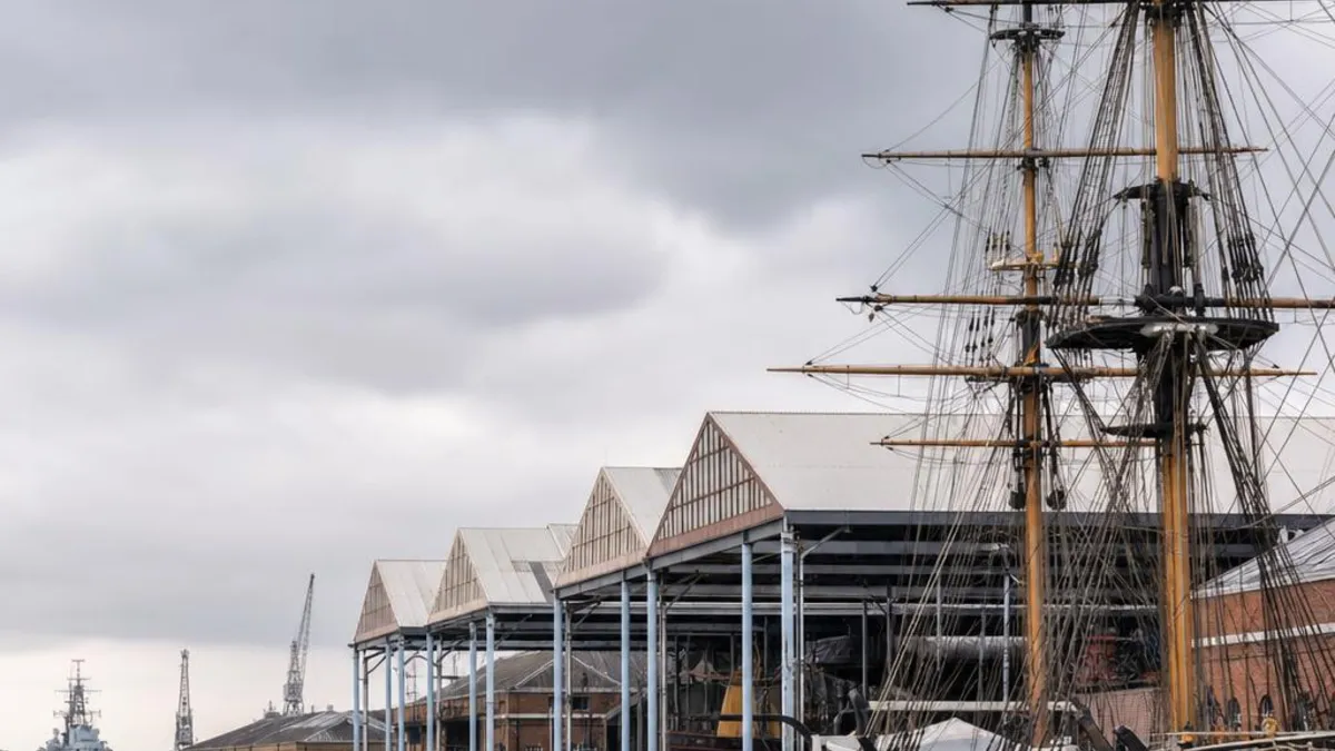 Victorian covered slipways and a preserved sailing warship at the historic Chatham Dockyard on the River Medway