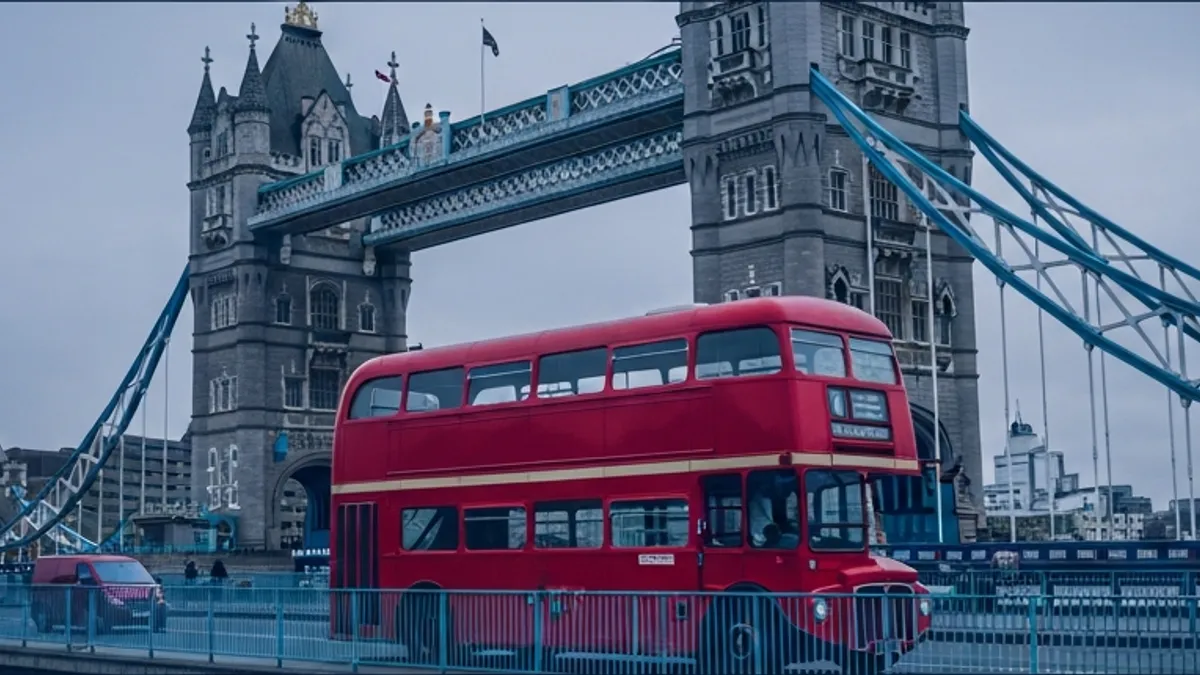 A red double-decker London bus crossing Tower Bridge